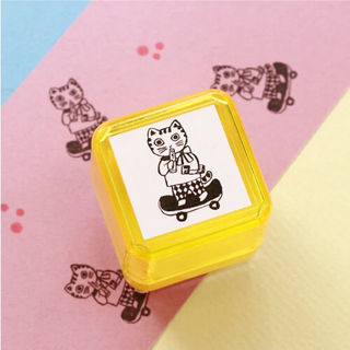 Yellow square stamp with a cat design on a pink background